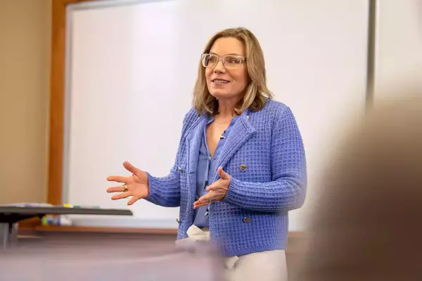 Kristina Swanson stands at the front of her class, teaching.